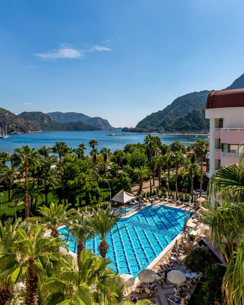 Bazén hotela Aqua 5* v Dalamane s výhľadom na tyrkysové more a zelené hory Turecka