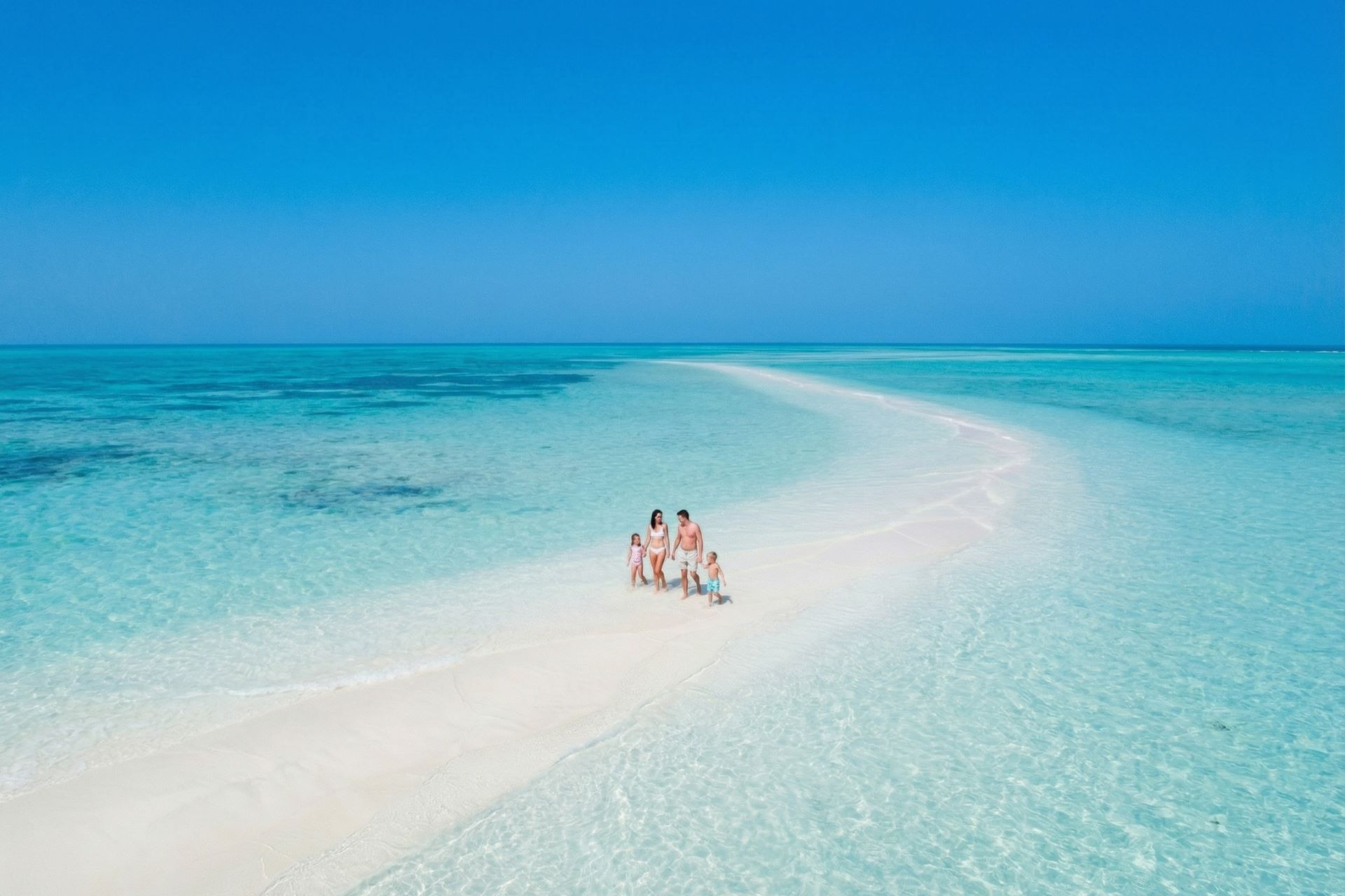 Rodina prechádzajúca sa na miznúcom ostrove Jarada v Bahrajne
